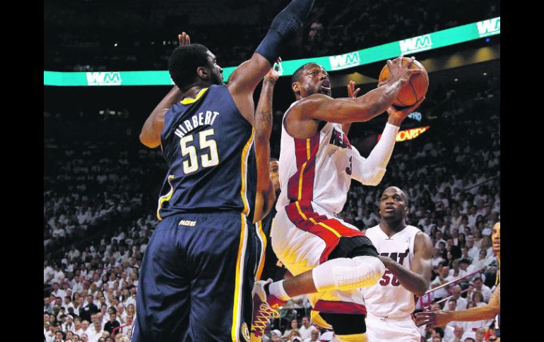 Dwyane Wade (centro), del Miami Heat, penetra la defensiva de Indiana y dispara a al canasta. AFP  /