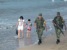 Soldados que llegaron a la costa jalisciense para apoyar en caso de desastre, hacen un rondín por la playa después del huracán. EFE  /