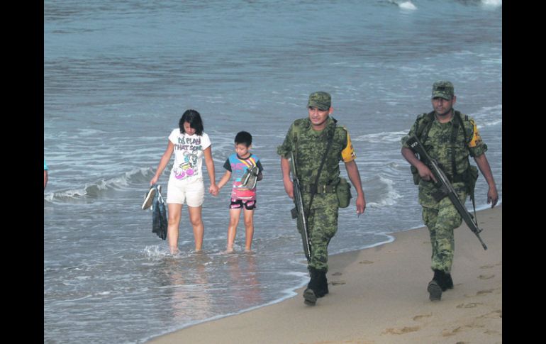 Soldados que llegaron a la costa jalisciense para apoyar en caso de desastre, hacen un rondín por la playa después del huracán. EFE  /