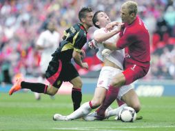 ACCIDENTAL. Cahill (centro) choca con su arquero Joe Hart, tras ser empujado por el belga Dries Martens. AFP  /