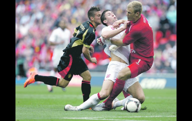 ACCIDENTAL. Cahill (centro) choca con su arquero Joe Hart, tras ser empujado por el belga Dries Martens. AFP  /