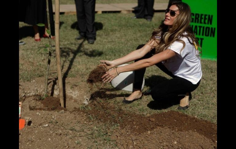 La supermodelo plantando un árbol como apoyo simbólico a Río+20. REUTERS  /