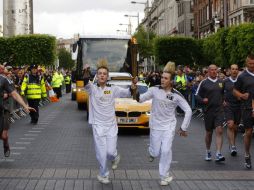 John (i) y Edward Grimes (d) llevan la llama olímpica por las calles de Dublín. AP  /