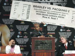 Tim Bradley sostiene un presunto boleto para la “revancha” entre ambos púgiles, mientras que Manny Pacquiao sonríe. AP  /