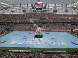 Cientos de voluntarios realizaron la coreografía sobre la cancha recubierta. AP  /