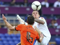 El capitán de Dinamarca, Danny Agger (derecha), le quita, sin tocarlo, un balón al delantero holandés Robin van Persie. EFE  /