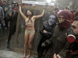 Un grupo de actores 'torura' a una mujer  durante una protesta contra el estreno de un documental sobre Pinochet. AP  /