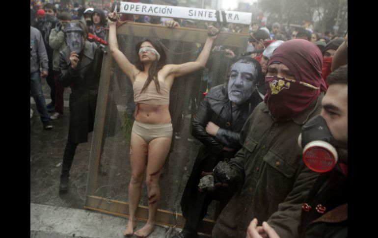 Un grupo de actores 'torura' a una mujer  durante una protesta contra el estreno de un documental sobre Pinochet. AP  /