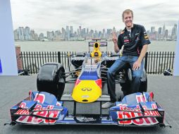 Presume bólido. Sebastian Vettel posa con su monoplaza, tras el “Día de Medios” en Nueva York.  AFP  /