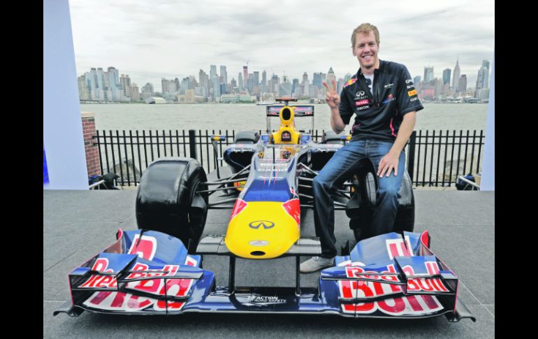 Presume bólido. Sebastian Vettel posa con su monoplaza, tras el “Día de Medios” en Nueva York.  AFP  /