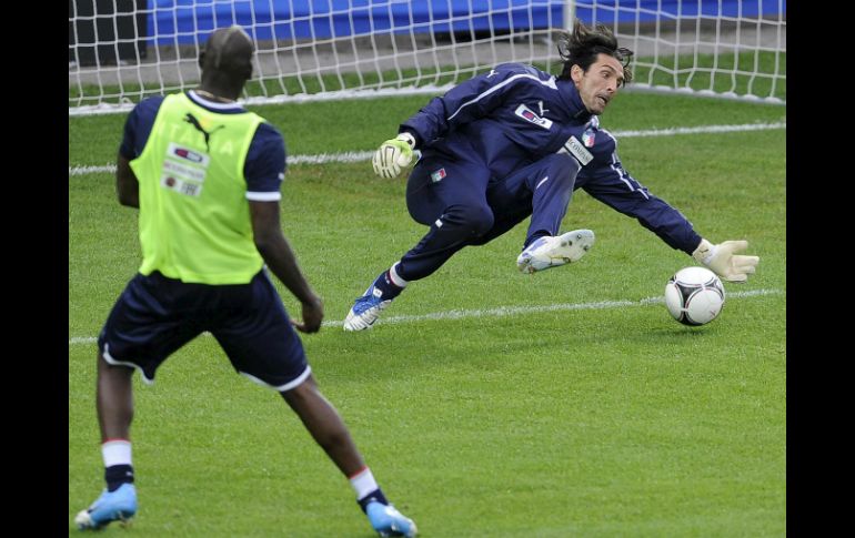 El guardameta italiano Gianluigi Buffon (d) para un balón lanzado por su compañero Mario Balotelli. EFE  /