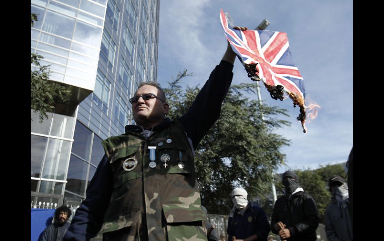 El excombatiente de la guerra de Malvinas, Marcelo Wytrykusz, quema una bandera del Reino Unido. EFE  /