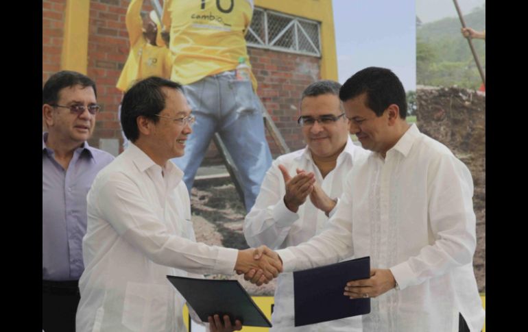 El canciller salvadoreño, Hugo Martínez (d), estrecha la mano del embajador de Taiwán en su país, Jaime Chen. EFE  /