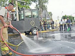 Bomberos limpian la zona del ataque, después de rescoger esquirlas y restos de los daños.  /