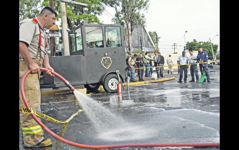 Bomberos limpian la zona del ataque, después de rescoger esquirlas y restos de los daños.  /