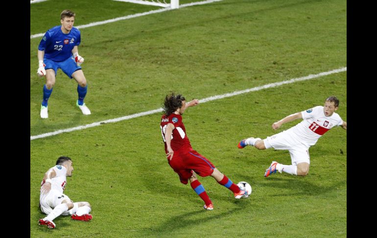 Jiracek (c) dispara entre dos defensas de Polonia para anotar el único gol del partido. EFE  /