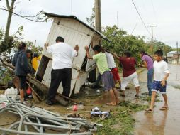 Residentes empujan un puesto derribado por el huracán Carlotta en la comunidad de Pluma Hidalgo, Oaxaca. REUTERS  /