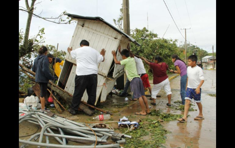 Residentes empujan un puesto derribado por el huracán Carlotta en la comunidad de Pluma Hidalgo, Oaxaca. REUTERS  /