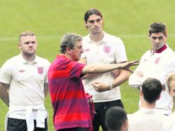 Rooney (i) escucha las indicaciones del técnico Roy Hodgson (c) durante el reconocimiento de la cancha donde hoy juegan. REUTERS  /