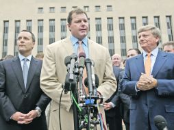 Roger Clemens habla con la prensa afuera de la corte, flanqueado por sus abogados. AP  /