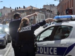 Oficiales de policía crean un cerco alrededor del banco donde se hallan los rehenes. AFP  /