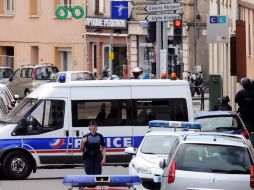 Tras la liberación de dos rehenes, la policía mantiene el cerco afuera del banco.  AFP  /