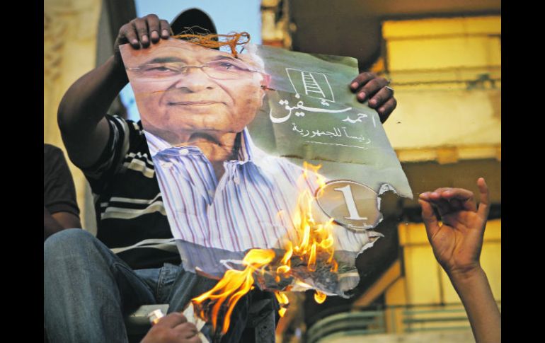 Partidarios del candidato islamita Mohamed Mursi, queman un póster de su rival y ex primer ministro de Mubarak, Ahmed Shafiq. AP  /