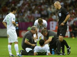 El portugués Helder Postiga (abajo) recibe tratamiento durante el partido de cuartos de final de la Eurocopa 2012. EFE  /