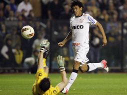 Romarinho (der) dispara ala salida del arquero para el gol del empate de Corinthians. AFP  /