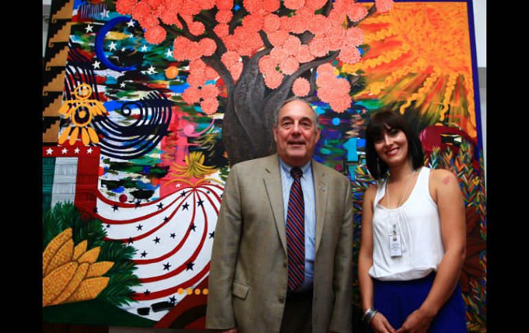 El cónsul, Daniel F. Keller y Verónica Yazmín posan junto al cuadro ''Festival de las uniones''.  /