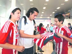 El defensa central de Chivas, Héctor Reynoso atiende a los aficionados del Rebaño en el Aeropuerto Internacional de Guadalajara.  /