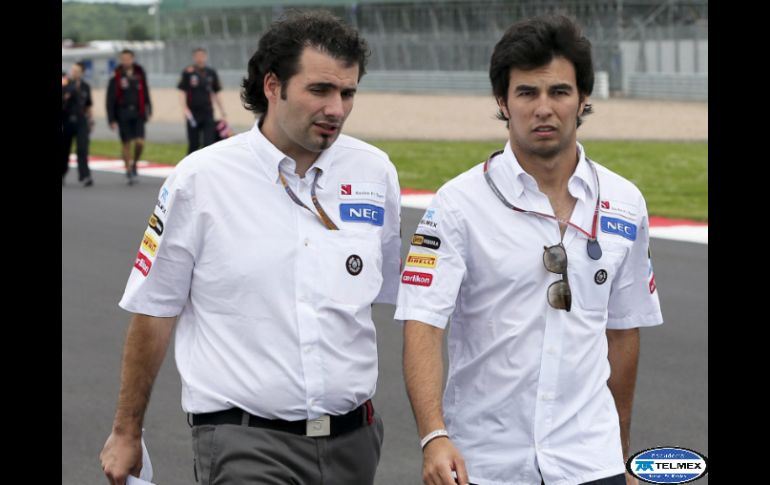 Sergio Pérez (d), fotografiado junto a uno de los miembros de su equipo en el circuito de Silverstone. EFE  /