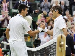 Djokovic y Federer se saludan luego de la semifinal varonil de Wimbledon, que se decantó para el suizo en cuatro sets. EFE  /