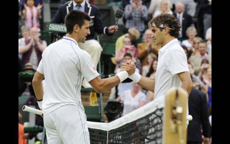 Djokovic y Federer se saludan luego de la semifinal varonil de Wimbledon, que se decantó para el suizo en cuatro sets. EFE  /