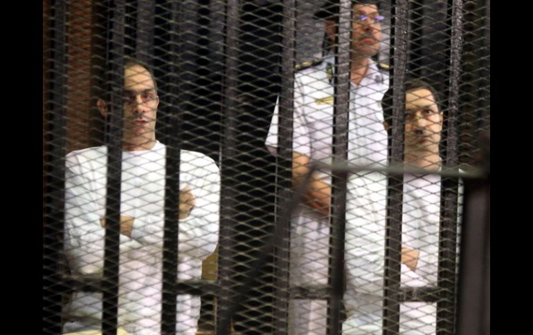 Gamal (i) y Alaa (d), hijos del ex presidente Mubarak, tras los barrotes durante su juicio en la Academia de Policía de El Cairo. EFE  /