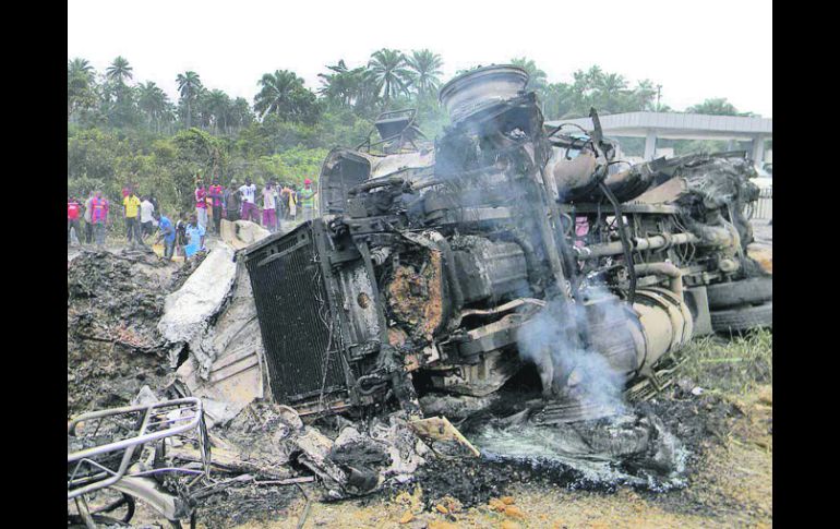 CENIZAS. Habitantes observan el lugar del accidente y posterior explosión de la pipa que transportaba gasolina. EFE  /