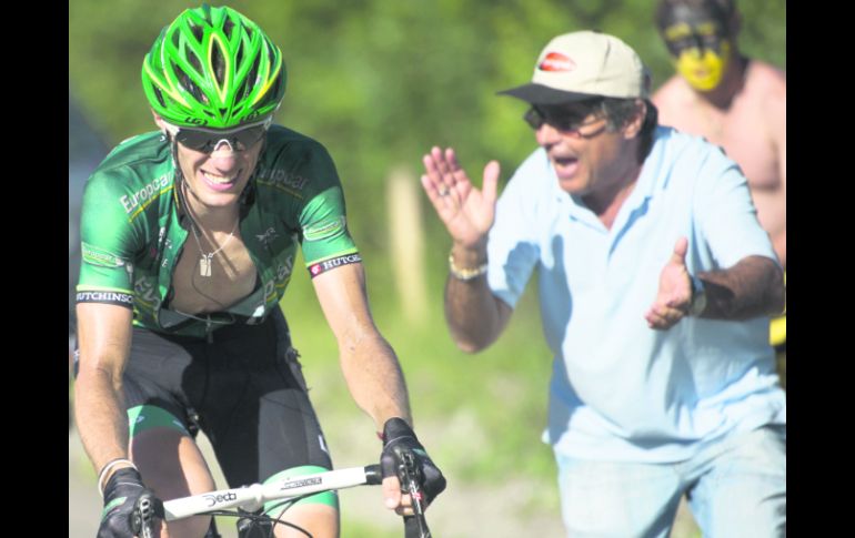 A SUFRIR. Pierre Rolland pedalea en el ascenso hacia la meta,  mientras un aficionado lo apoya. AP  /