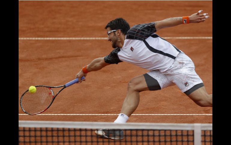 El serbio le regresa una bola a Juan Mónaco de Argentina en la final. REUTERS  /