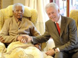 El ex presiente de Sudáfrica y Premio Nobel de la Paz Nelson Mandela saluda a Bill Clinton. EFE  /