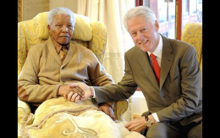 El ex presiente de Sudáfrica y Premio Nobel de la Paz Nelson Mandela saluda a Bill Clinton. EFE  /