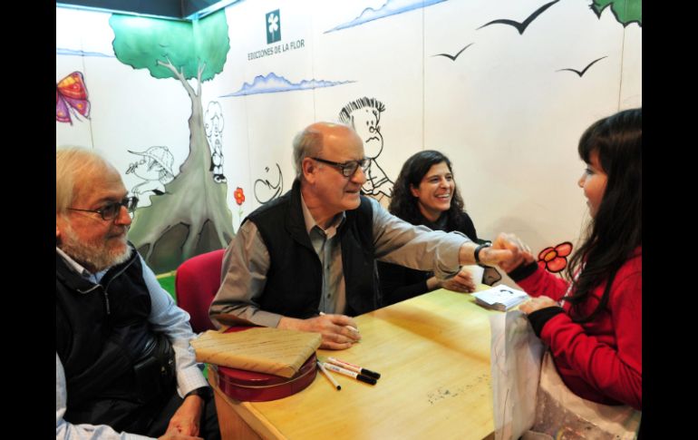 El caricaturista argentino Joaquín Lavado, 'Quino', saluda a una niña durante la Feria del Libro Infantil de Buenos Aires. EFE  /