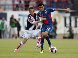 Mauro Cejas, de Pachuca (i), y Ray Torres, de Atlante, disputan un balón durante el juego. MEXSPORT  /