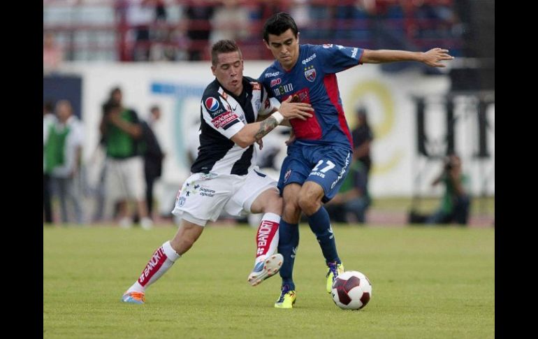 Mauro Cejas, de Pachuca (i), y Ray Torres, de Atlante, disputan un balón durante el juego. MEXSPORT  /