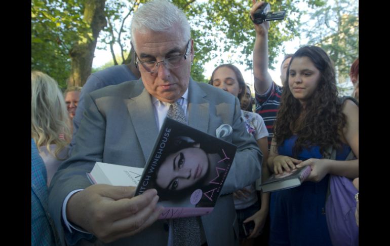 El padre de la cantante, Mitch Winehouse, firma autógrafos para los fans. AP  /