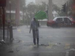 Un hombre trata de combatir la lluvia provocada por el tifón ''Vicente''. EFE  /