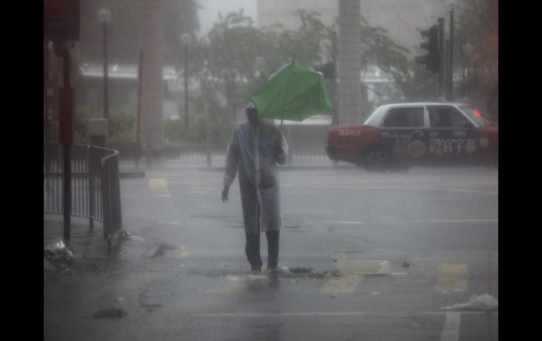 Un hombre trata de combatir la lluvia provocada por el tifón ''Vicente''. EFE  /