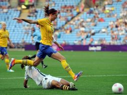 La sueca Lotta Schelin controla el balón saltando sobre la sudafricana Amanda Sister. EFE  /