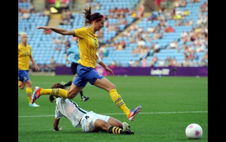 La sueca Lotta Schelin controla el balón saltando sobre la sudafricana Amanda Sister. EFE  /