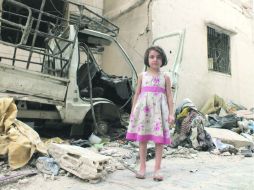 Una niña siria posa para el fotógrafo Yazen Homsy en un marco de destrucción en un barrio de la ciudad de Homs. REUTERS  /