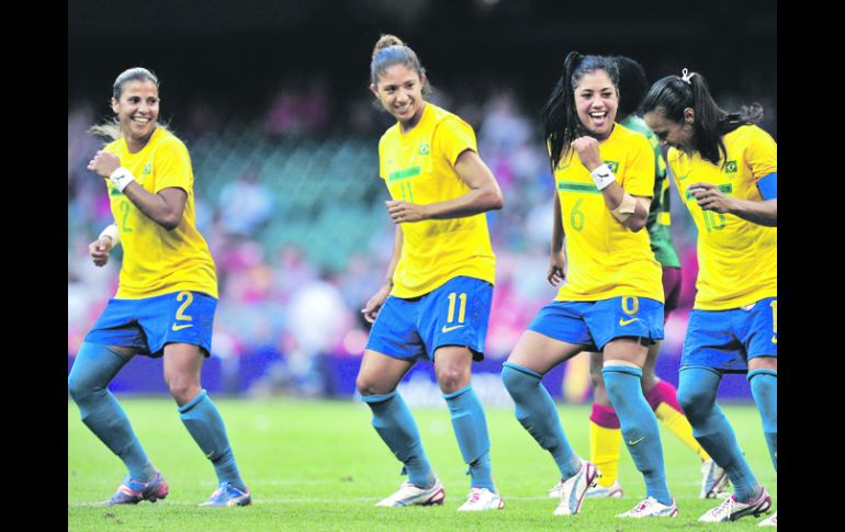 Con Ritmo. La super estrella brasileña, la atacante Marta (10), festeja su primer gol con sus compañeras Maurine (6) y Cristiane. AFP  /